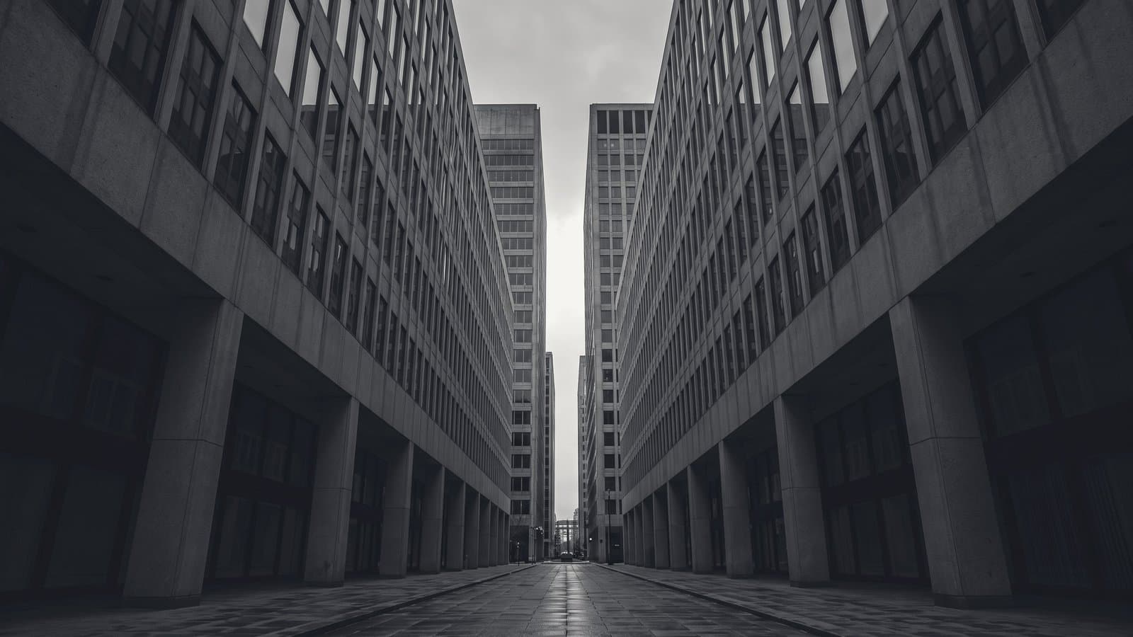 A narrow canyon between two modernist office towers, a thin slot of sky far above.